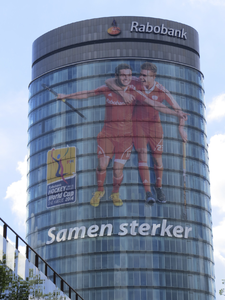 906948 Gezicht op de kantoortoren van het Hoofdkantoor Rabobank Nederland (Croeselaan 18) te Utrecht, met een grote ...